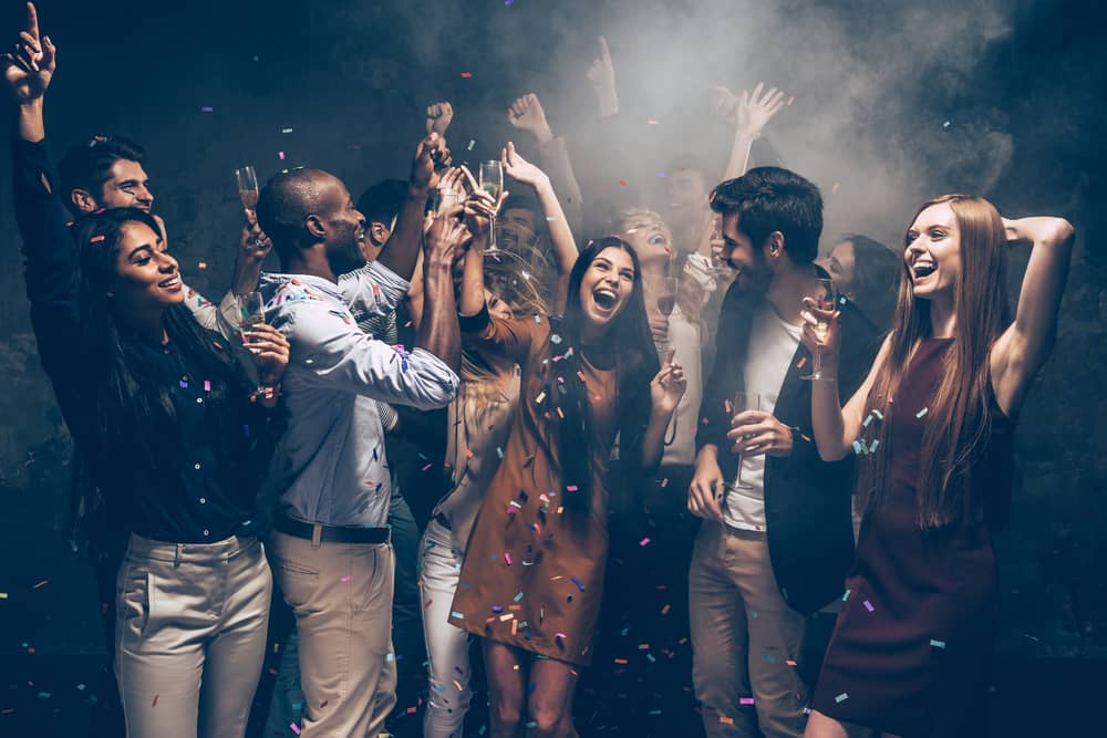 Group of young adults celebrating at a packed Fremont Street club during a downtown Vegas crawl